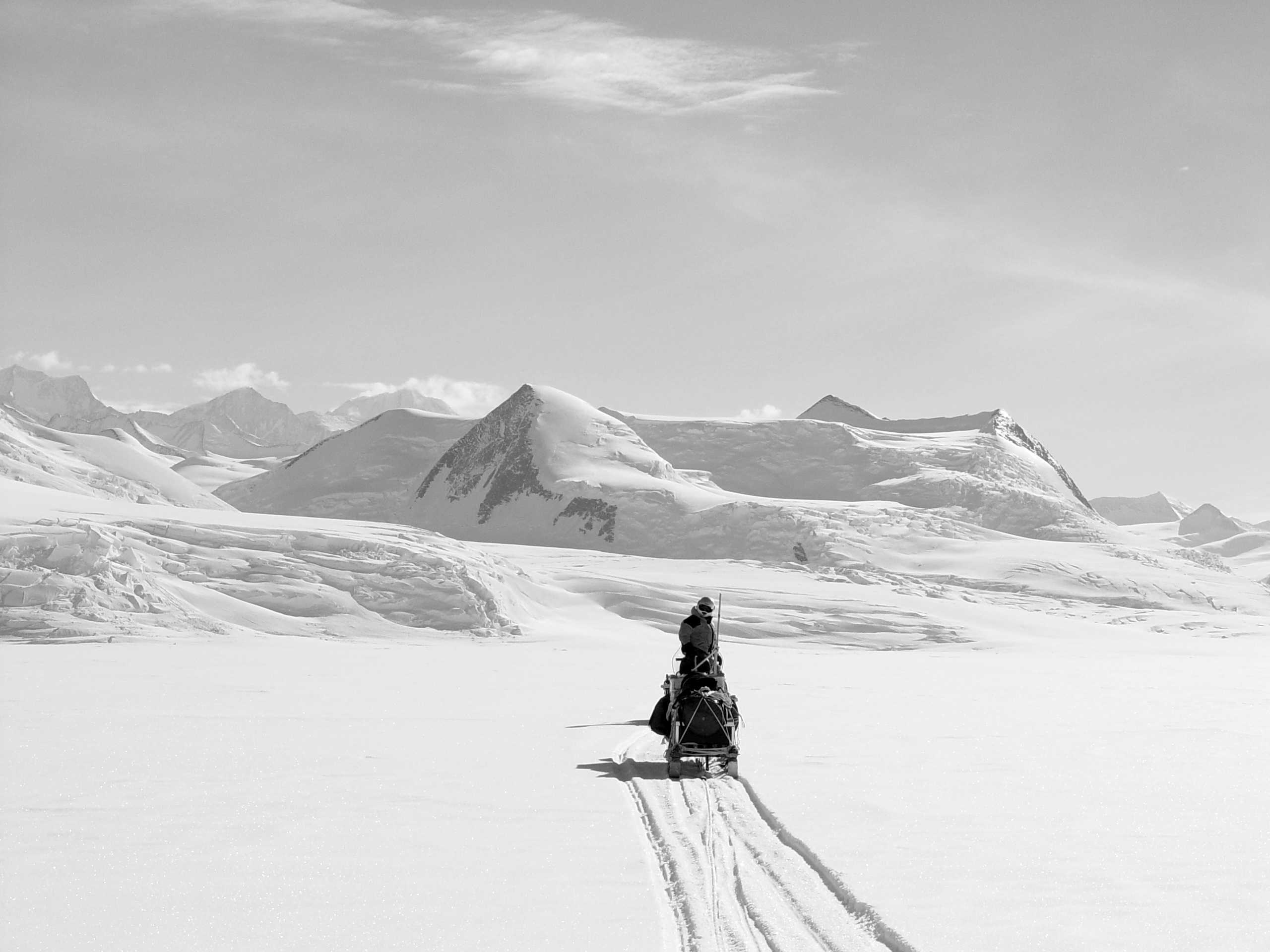 a man riding skis down a snow covered mountain
