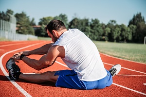 Image showing athlete stretching on a track