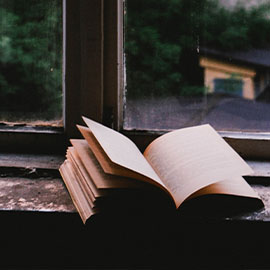 Image of an open book on a windowsill 