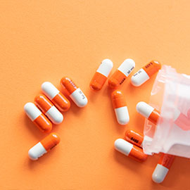 Orange and white pills on an orange background