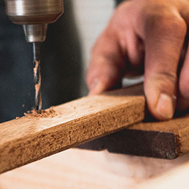 Close up of someone drilling a piece of wood