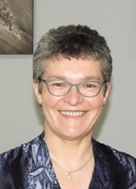 a person wearing glasses and smiling at the camera