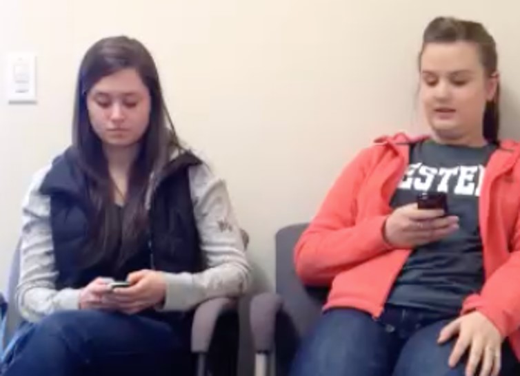 Two friends being distracted by their phones