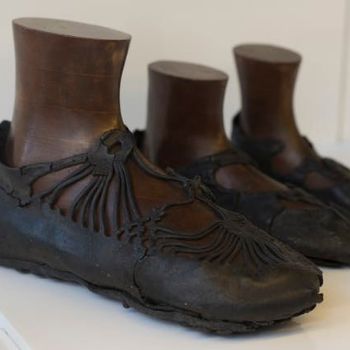 Caption: Items like these Roman black leather shoes are often found preserved in peat.