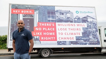 Caption:Sanj Srikanthan, ShelterBox Chief Executive, pictured with the billboard