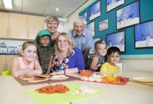 Caption:Prof. Greta Defeyter with Jeremy Cripps of Children North East, helping to make healthy lunches with Gillian Gibson and children at Bridgewater Primary School holiday club