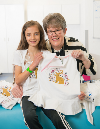 Caption: Patient Sienna Steele, aged 10, with Denise Crawford and some of the modified t-shirts.