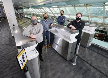 Caption:Pictured left to right are Kieran Dougan, Simon Scott-Harden and Howard Fenwick of Northumbria University, and Andrew Sambell of British Engines, with the FLO-SAN hand sanitisation unit at Newcastle Airport