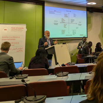 Caption: Professor Matt Baillie Smith speaking in Geneva at the International Conference of the Red Cross and Red Crescent.