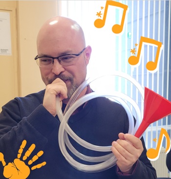 a man playing a trumpet made from a funnel and a hose