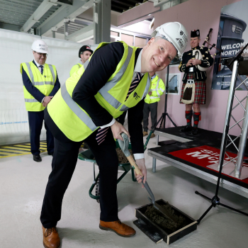 Caption:Professor John Woodward pouring final concrete at NESST topping out ceremony