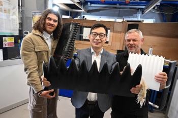 caption:The Northumbria University WHOWL project team from l-r post graduate research student Vlad Volodkovic, Senior Lecturer in Aerodynamics Dr Xiang (Shaun) Shen, and senior faculty technician Martin Purvis, pictured with prototype turbine blade designs, next to Northumbria's wind tunnel.