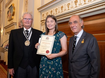Caption: Laura Watson with Master Glover Clive Hawkins (left) and Robert Yentob, Chairman of Dents of Warminster and holders of the Royal Warrant.