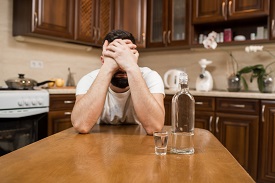 a person sitting at a table in a kitchen