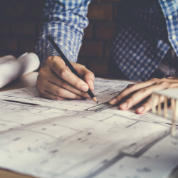 Man sketching design plans on paper. Photo credit: Akin Kaelyn/Shutterstock