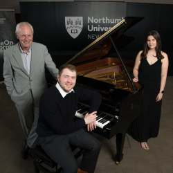 Final year Music Degree students Allan Colver, Jeremy Teasdale and Caitlin Hedley, pictured standing next to a grand piano