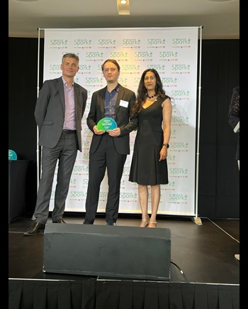 Caption: Arthur collecting his award with Richard Watts and Isabella Mascarenhas photo by Robbie Dunion