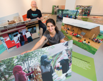 Professor Matt Baillie Smith and Dr Bianca Fadel help install the exhibition of photographs taken by young refugees in Uganda as part of the RYVU project.