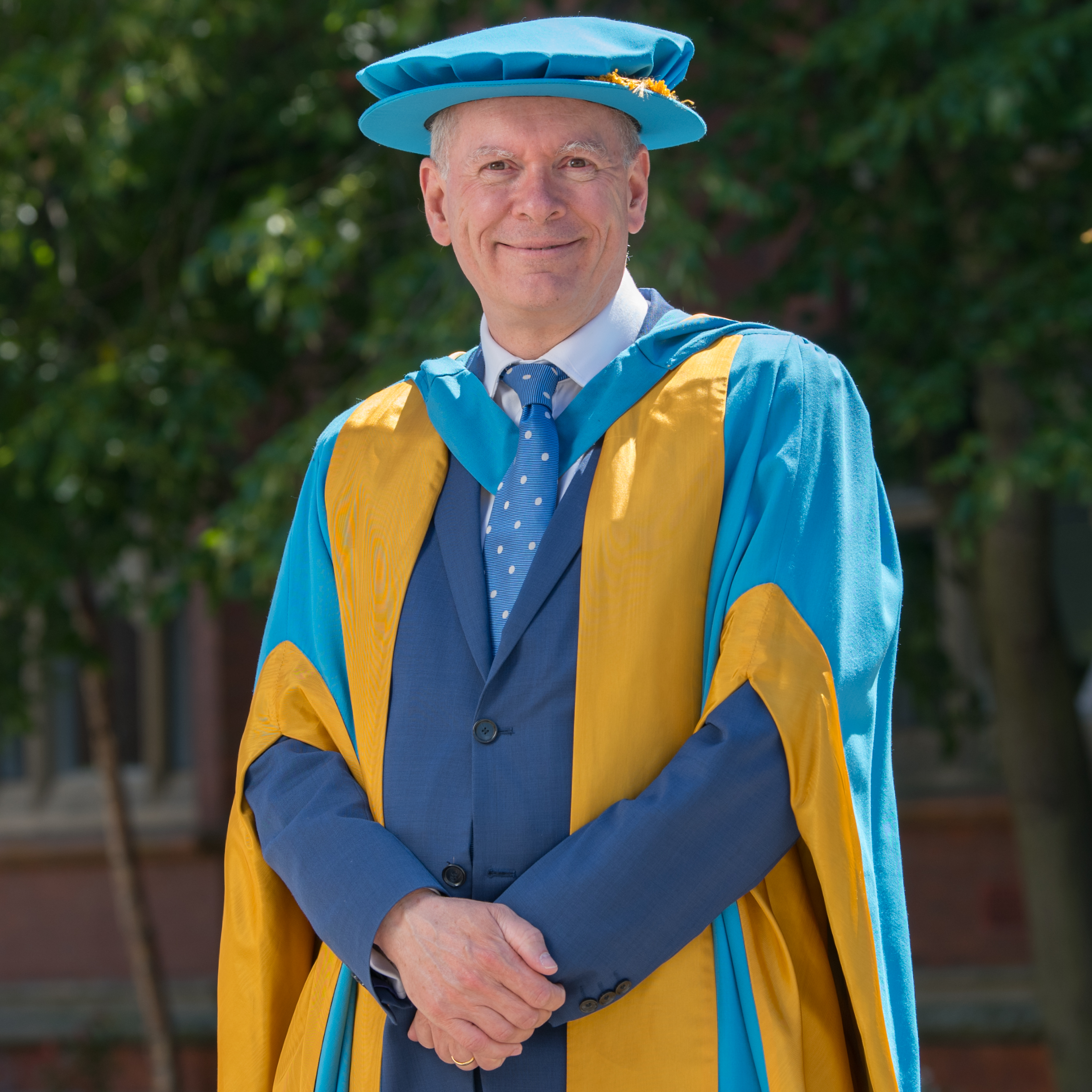 Professor Andrew Wathey standing on Northumbria University's City Campus before in academic dress before receiving his Honorary Degree