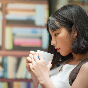 Woman experiencing altered sense of taste and smell while drinking coffee