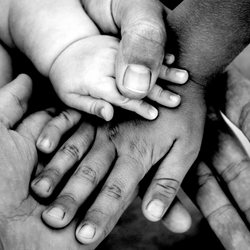 a black and white image of hands young and old