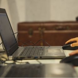 image of a laptop with a hand holding a computer mouse