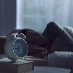 Sleeping woman next to a clock