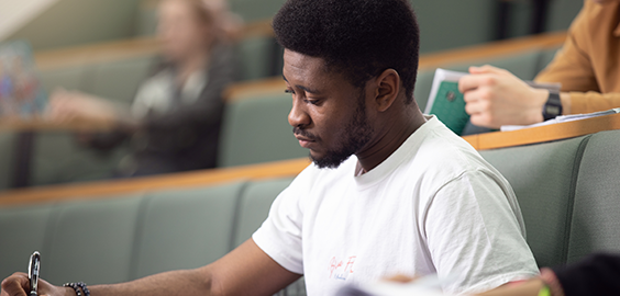 Male student studying in a lecture hall