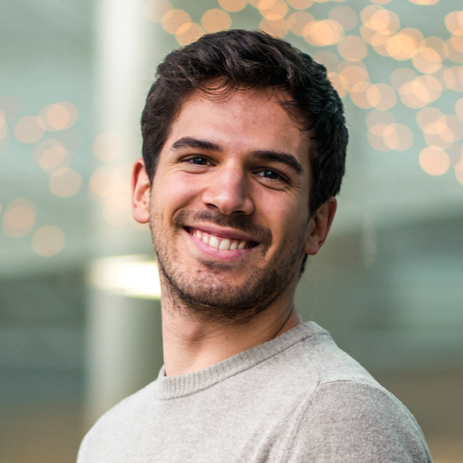 a man wearing glasses and smiling at the camera