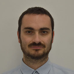 a man wearing glasses and smiling at the camera