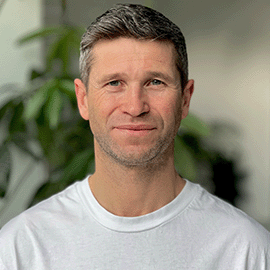 Man smiling at camera wearing white t-shirt