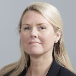 a woman wearing glasses and smiling at the camera