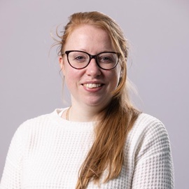 Lady with ginger hair and black rimmed glasses