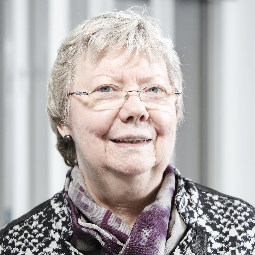 a man wearing glasses and smiling at the camera