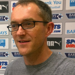 a man wearing glasses and smiling at the camera