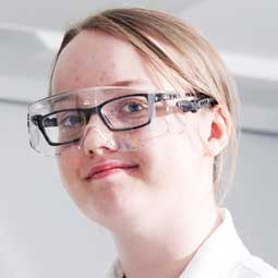 a person wearing glasses and smiling at the camera