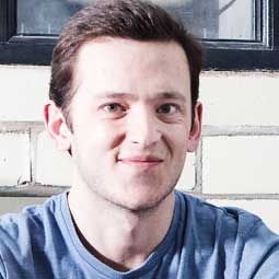 a man sitting in front of a window posing for the camera