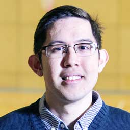 a man wearing glasses and smiling at the camera