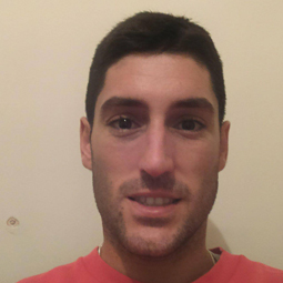 a man wearing glasses and smiling at the camera