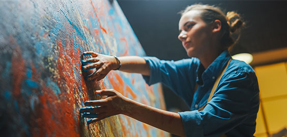 girl painting on canvas with her fingers