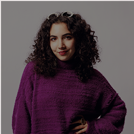 Image of student wearing a purple sweater smiling at the camera