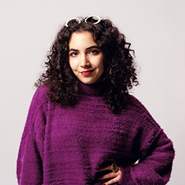 Image of student wearing a purple sweater smiling at the camera