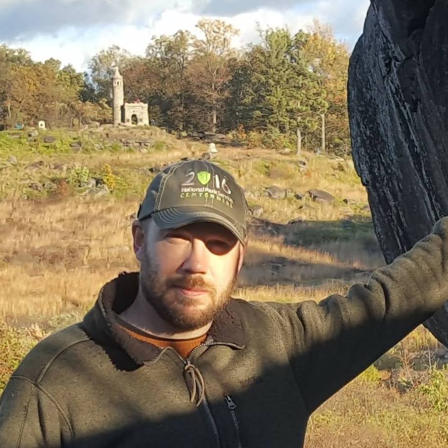 a man standing on top of a grass covered field