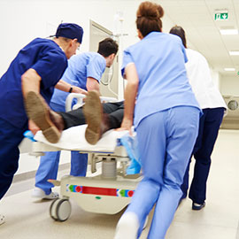 Emergency service staff pushing hospital bed