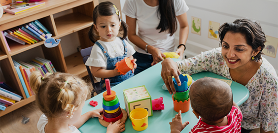 children and teachers in primary school sitting at a table