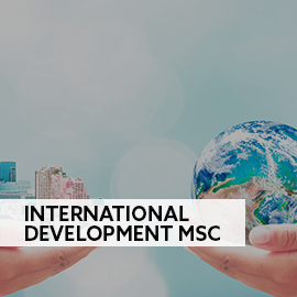 two hands holding a miniature globe and a miniature metropolis 