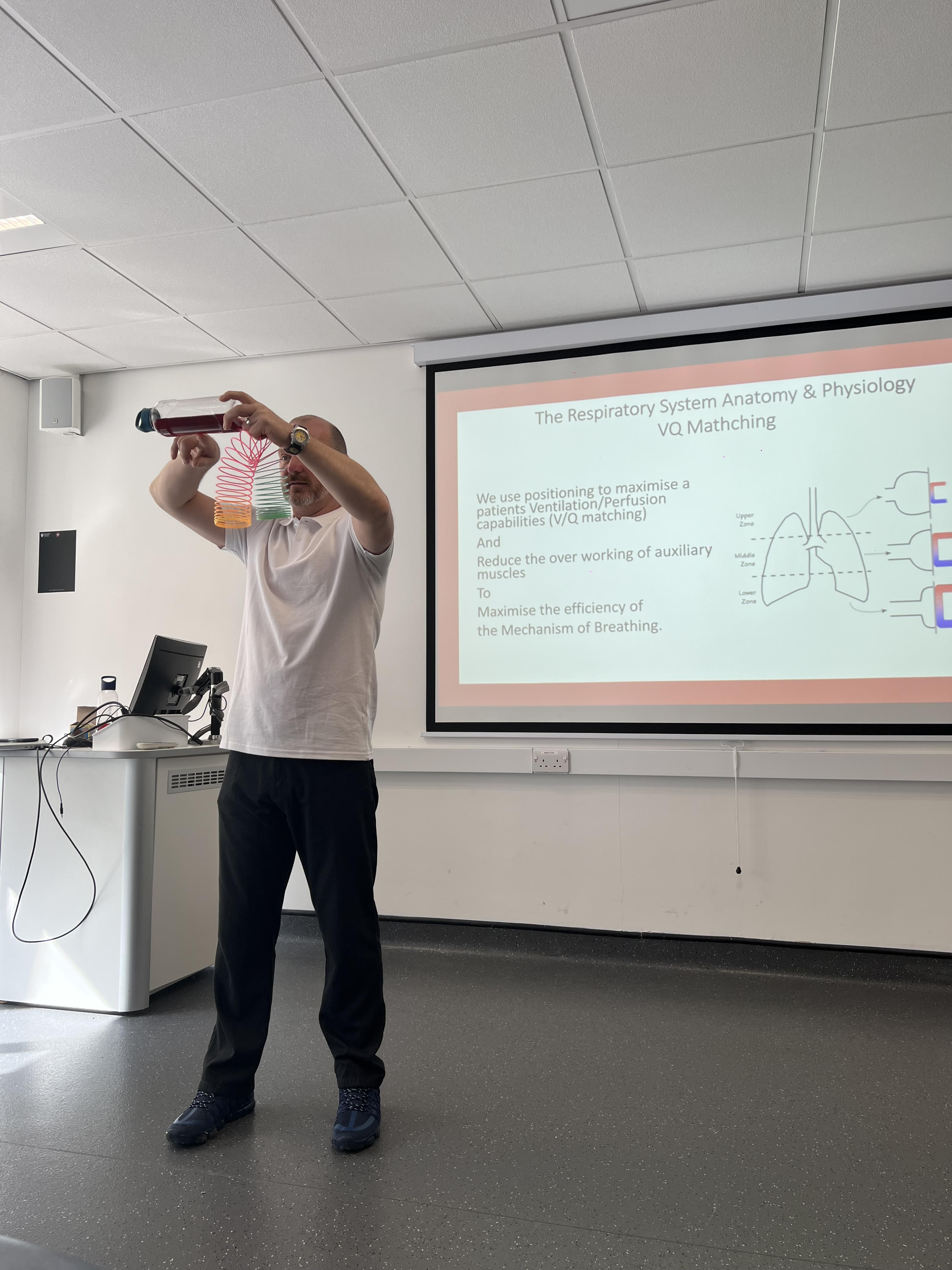 a man demonstrating VQ matching with bottle and slinky