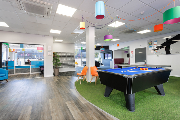 Open plan games rooms with pool table and reception desk. 