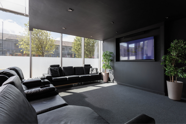 TV room with L-shaped sofa and large TV Screen. 