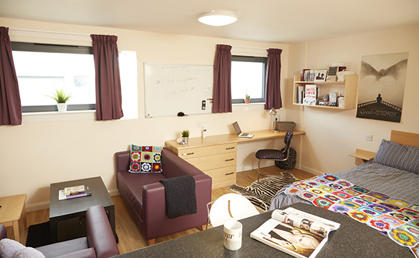 Trinity Square accommodation studio flat with a double bed, desk and a seating area, decorated with personal items